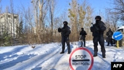 FILE - Servicemen take part in special exercises of the Ukrainian Ministry of Internal Affairs, the Ukrainian National Guard and Ministry Emergency in a ghost city of Pripyat, near Chernobyl Nuclear Power Plant, Feb. 4, 2022. Ukraine announced on February