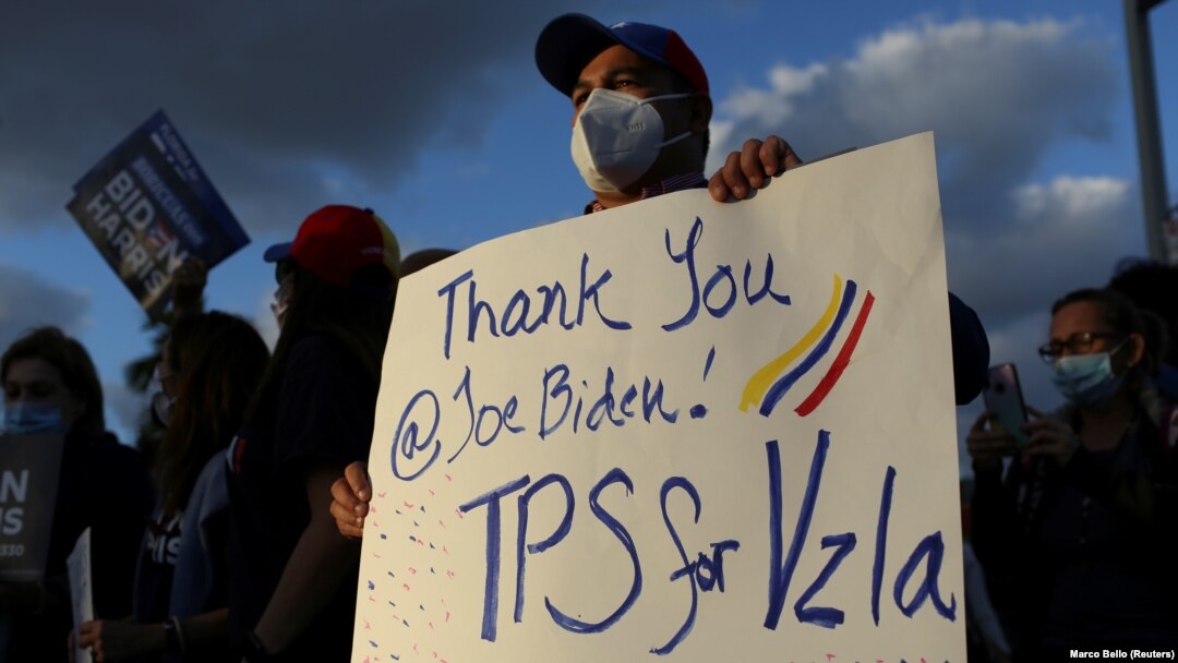 Seorang pria memegang poster bersama warga komunitas Venezuela menyusul pengumuman oleh pemerintahan Biden bahwa akan memberikan status perlindungan sementara (TPS) untuk migran Venezuela yang tinggal di AS, di Doral, Florida, 9 Maret 2021. (Foto: Reuters