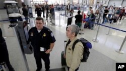 U.S. Customs and Border Protection supervisor Erik Gordon, left, helps a passenger navigate one of the new facial recognition kiosks at a United Airlines gate before boarding a flight to Tokyo, Wednesday, July 12, 2017, at George Bush Intercontinental Air