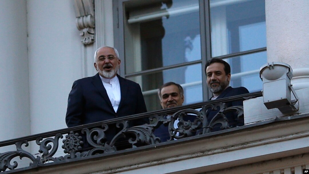 Iranian Foreign Minister Mohammad Javad Zarif (L) talks to journalist from a balcony of the Palais Coburg hotel where the Iran nuclear talks are being held in Vienna, Austria, July 9, 2015.