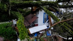 FILE - A damaged 100-year-old home is seen after an Oak tree landed on it after Hurricane Helene moved through the area, in Valdosta, Georgia, Sept. 27, 2024.