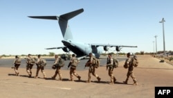 Des soldats français de l'opération Barkhane passant devant un Airbus A-400 M Atlas de l'armée de l'air française à la base militaire française de Tombouctou, au Mali, le 5 décembre 2021.