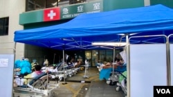 香港第5波新冠病毒疫情引致公營醫療系統超負荷，多間公立醫院急症室逼爆，大批病人被安置在戶外的病床上，有懷疑確診者及家人，到私立醫院急症室求診 （美國之音湯惠芸）