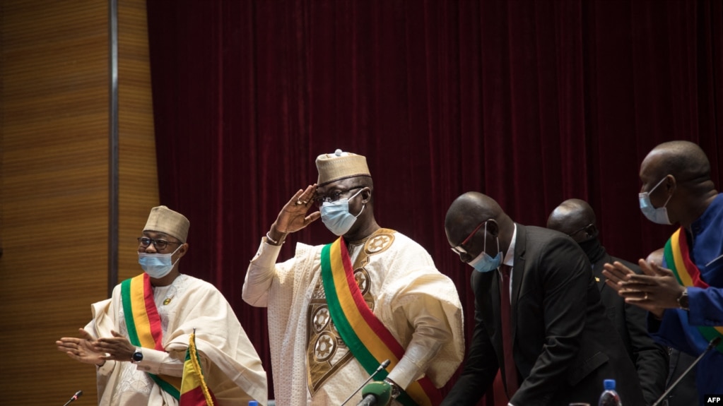 Le président du Conseil national de transition, Malick Diawa, salue les membres du conseil lors d'une réunion pour voter une charte révisée à Bamako le 21 février 2022.