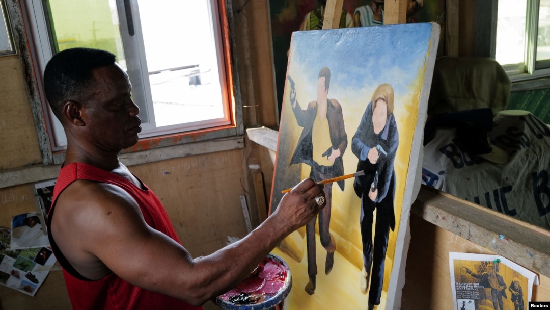 Ghanaian movie poster artist Daniel Anum Jasper, 54, works on a commissioned movie poster for a foreign client at his workshop in the Teshie area of Accra, Ghana, Feb. 11, 2022.