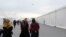Afghan refugees walk alongside temporary housing in Liberty Village at Joint Base McGuire-Dix-Lakehurst in Trenton, New Jersey, Dec. 2, 2021.