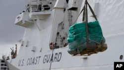 A palette loaded with seized cocaine and marijuana is lowered by a crane, as the U.S. Coast Guard unloads more than one billion dollars worth of seized drugs from the Coast Guard Cutter James, at Port Everglades, in Fort Lauderdale, Florida, Feb. 17, 2022