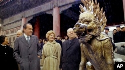 FILE - Then U.S. President Richard Nixon and then first lady Pat Nixon looks at a sculpture depicting a mythical beast on the palace grounds of Beijing's Forbidden City as heavy snow falls on Feb. 25, 1972.