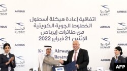 Ketua Kuwait Airways Ali al-Dakhnan (tengah kiri) berjabat tangan dengan Mikail Houari, Presiden Airbus Afrika dan Timur Tengah, setelah menandatangani kesepakatan di markas besar Kuwait Airways, 21 Februari 2022. (KUNA / AFP) 