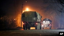 Military trucks move down a street outside Donetsk, the territory controlled by pro-Russian militants, eastern Ukraine, Feb. 22, 2022.