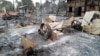 FILE - Charred homes sit in piles of ash in Mwe Tone village of Pale township in the Sagaing region, Myanmar, Feb. 1, 2022. 
