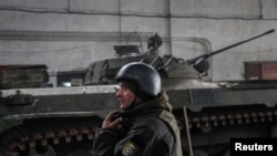 A Ukrainian service member stands near an infantry fighting vehicle on the front line near the city of Novoluhanske in the Donetsk region, Ukraine, Feb. 22, 2022.