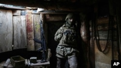 A Ukrainian serviceman stands in a shelter on a position at the line of separation between Ukraine-held territory and rebel-held territory near Zolote, Ukraine, Feb. 19, 2022. 