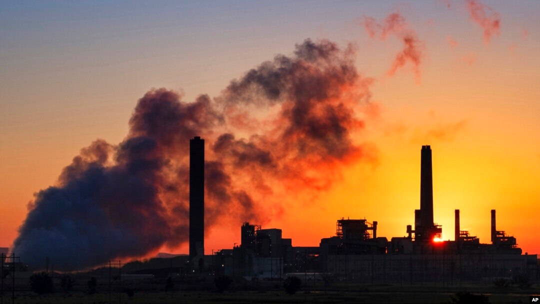 FILE - A coal-fired power plant is silhouetted against the morning sun in Wyoming in July 2018.