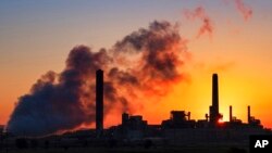 FILE - A coal-fired power plant is silhouetted against the morning sun in Wyoming in July 2018.