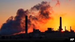 FILE - A coal-fired power plant is silhouetted against the morning sun in Wyoming in July 2018.