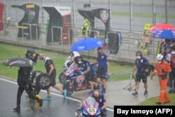 Drivers and pit crew leave the gridline due to rain during the World Superbike Championship at the Mandalika Circuit.  (Photo: AFP/Bay ismoyo)
