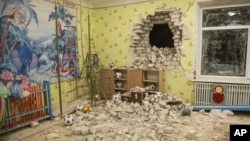 Ladrillos y escombros se mezclan con juguetes debajo de una pared dañada después del bombardeo reportado en un jardín de infantes en el asentamiento de Stanytsia Luhanska, Ucrania, el jueves 17 de febrero de 2022 a última hora.