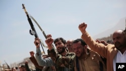 FILE - Armed Houthi fighters attend the funeral procession of Houthi rebel fighters who were killed in recent fighting with forces of Yemen's internationally recognized government, in Sanaa, Yemen, on Nov. 24, 2021.