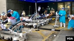 香港第5波新冠病毒疫情引致醫療系統超出負荷，明愛醫院急症室外2月18日下午仍有大批等候入院的病人，被安排在戶外的病床上 （美國之音湯惠芸）