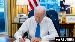 Perezida Joe Biden asinya itegeko rya perezida ribuza uguhanahana urudandaza no gushinga imitahe mu ntara zibiri ziyonkoye kuri Ukraine, White House i Washington, kw'itariki ya 21/02/2022