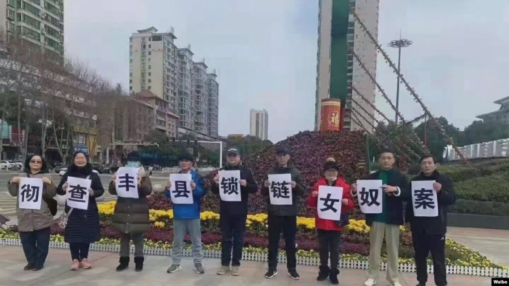 中国民众走上湖南岳阳街头举牌呼吁彻查锁链女奴案。（取自推特照片）