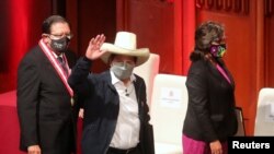 El presidente de Perú, Pedro Castillo, saluda junto a su vicepresidenta, Dina Boluarte, luego de recibir las credenciales de la autoridad electoral, en Lima, Perú, el 23 de julio de 2021.