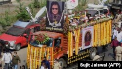 Les gens défilent lors du cortège funèbre du défunt chanteur-compositeur indien Bappi Lahiri à Mumbai le 17 février 2022.