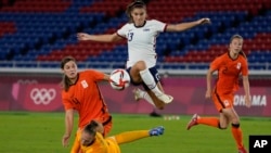 FILE - United States' Alex Morgan jumps over Netherlands' goalkeeper Sari van Veenendaal as she attempts to score during a women's quarterfinal soccer match at the 2020 Summer Olympics, July 30, 2021, in Yokohama, Japan.
