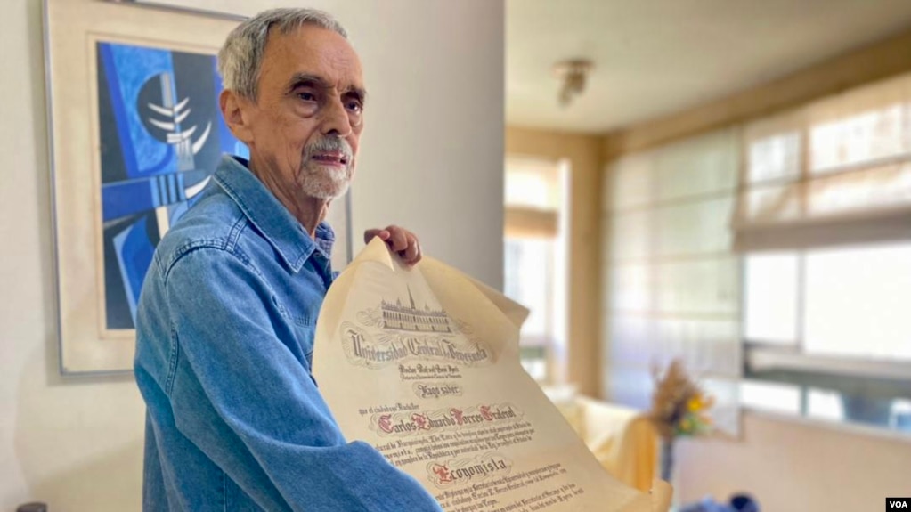 El profesor venezolano Carlos Torres muestra su diploma universitario mientras conversa con la Voz de América en Caracas. Febrero, 2022. Foto: Adriana Núñez Rabascall. 