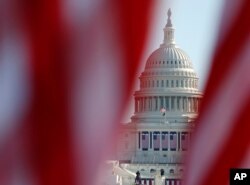 FILE - The U.S. Capitol is seen through a display of flags on the National Mall, one day after the inauguration of President Joe Biden, on Jan. 21, 2021, in Washington.