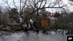 A boat hangs from a tree that was uprooted by storm Eunice in Voorburg, the Netherlands, Feb. 18, 2022.