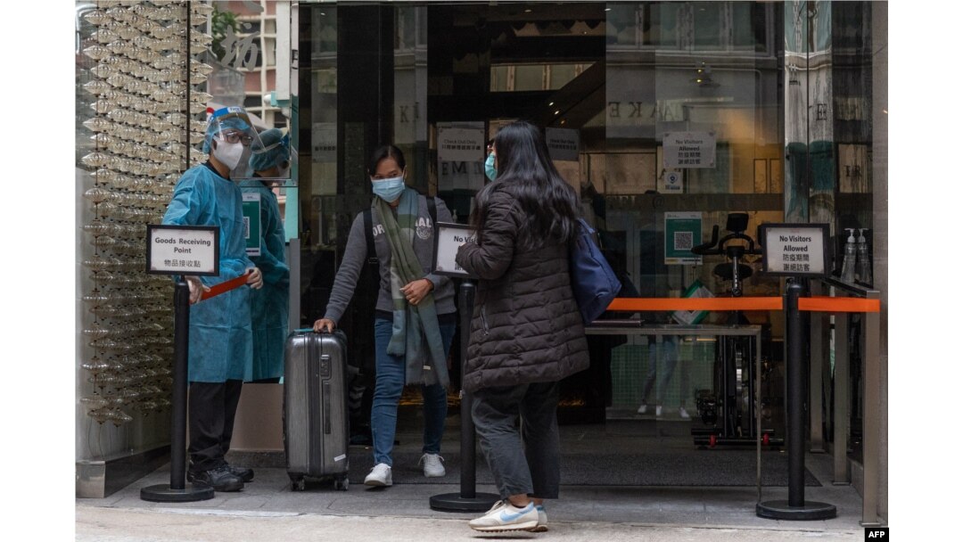 A woman leaves a quarantine hotel in Hong Kong's Centrals area on February 6, 2022, as authorities on February 5 announced a record number of new infections.