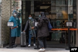 A woman leaves a quarantine hotel in Hong Kong's Centrals area on February 6, 2022, as authorities on February 5 announced a record number of new infections.