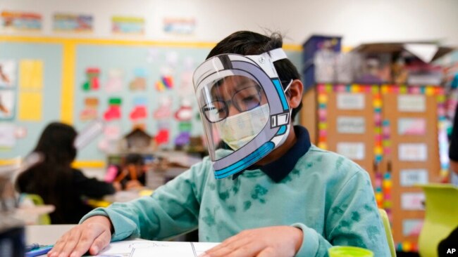 Seorang siswa menggunakan masker dan pelindung wajah saat menghadiri kegiatan belajar di Sekolah Dasar Washington di Lynwood, California, pada 12 Januari 2022. (Foto: AP/Marcio Jose Sanchez)
