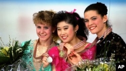 FILE - In this March 12, 1991 photo, U.S. skaters, left to right, include Tonya Harding who won silver; Kristi Yamaguchi who won gold; and Nancy Kerrigan who won bronze, display their medals at the World Figure Skating Championships in Munich, Germany.