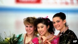 FILE - In this March 12, 1991 photo, U.S. skaters (L to R) Tonya Harding, silver; Kristi Yamaguchi, gold; and Nancy Kerrigan, bronze, display their medals after the finals of the World Figure Skating Championships in Munich.