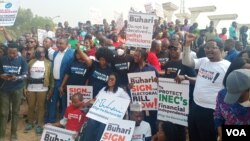 Protesters from various civil society groups hold placards in Abuja demanding president Buhari to sign the electoral bill in Abuja On Tuesday, February 22, 2022. (VOA/Timothy Obiezu)