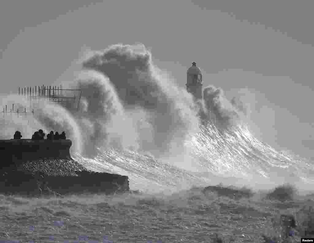 Waves crash against a lighthouse during Storm Franklin in Porthcawl, Wales, Britain.