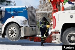 A man prepares a truck for towing, as truckers and supporters protest COVID-19 vaccine mandates, in Ottawa, Ontario, Canada, Feb. 18, 2022.