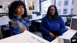 Amber Payne, left, and Deborah Douglas co-editors-in-chief of the new online publication of "The Emancipator" pose at their office inside the Boston Globe, Feb. 2, 2022, in Boston.