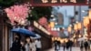 Orang-orang berjalan melalui jalan perbelanjaan di sepanjang kuil Sensoji yang terkenal di lingkungan Asakusa di Tokyo. (Foto: AP)