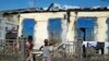 FILE — People stand outside a ruined home in Mananjary, Madagascar, Feb. 10, 2022. 