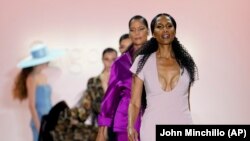 Fashion from Sergio Hudson's fall/winter 2022 collection is modeled by Beverly Johnson, front, during Fashion Week, Sunday, Feb. 13, 2022, in New York. (AP Photo/John Minchillo)