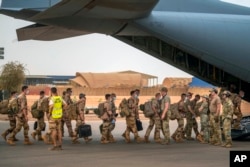 FILE - French Barkhane force soldiers who wrapped up a tour of duty in the Sahel leave their base on a transport plane in Gao, Mali, June 9, 2021.