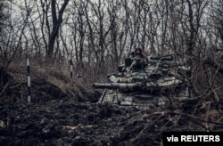 A service member of the Ukrainian Naval Infantry Corps (Marine Corps) rides a tank during drills at a training ground in an unknown location in Ukraine, in this handout picture released Feb. 18, 2022. (Press Service of the Ukrainian Naval Forces/Handout via Reuters)