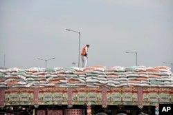 An Afghani truck driver ties a rope as trucks carrying wheat from India wait to pass through the Attari-Wagah border between India and Pakistan, near Amritsar, India, Feb.22, 2022.