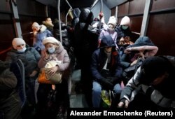 Orang-orang terlihat di dalam bus yang diatur untuk mengevakuasi penduduk setempat, di kota Donetsk yang dikuasai pemberontak, Ukraina, 18 Februari 2022. (Foto: REUTERS/Alexander Ermochenko)