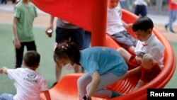 FILE - Children at a playground inside a shopping complex in Shanghai, China, June 1, 2021.
