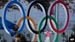 一名运动员站在北京冬奥赛场的奥运会五环里。（2022年2月3日）